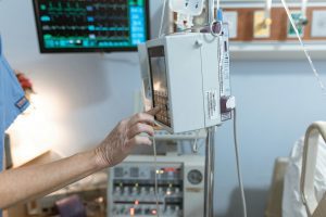 Um médico mexendo em uma bomba de infusão