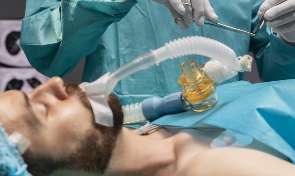 paciente sendo intubado por médico em sala cirúrgica