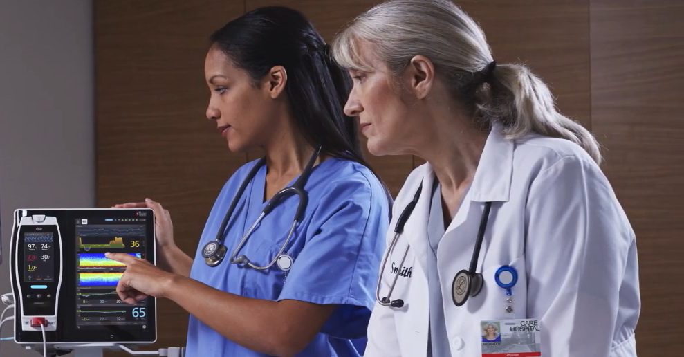 profissionais da saúde analisando parâmetros do monitor sedline