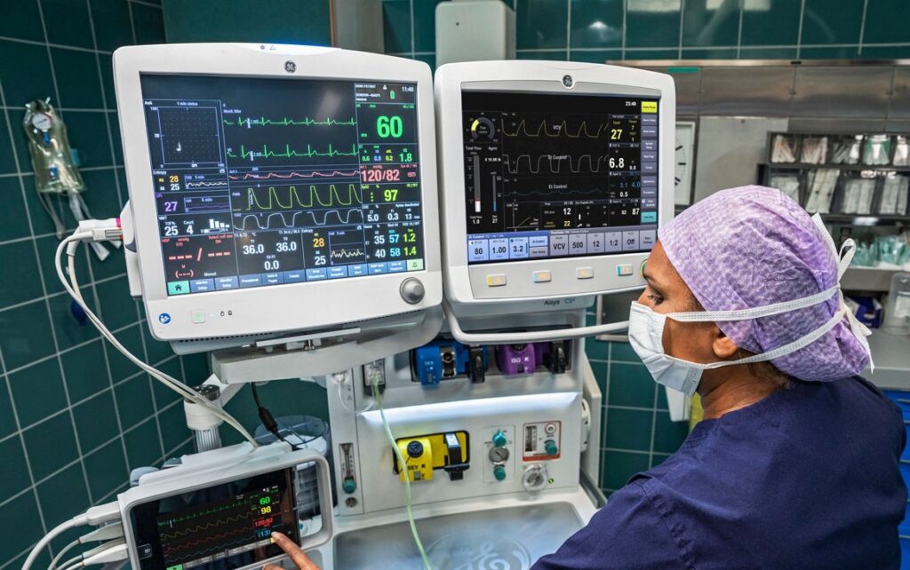 médica operando monitor e aparelho de anestesia ge healthcare