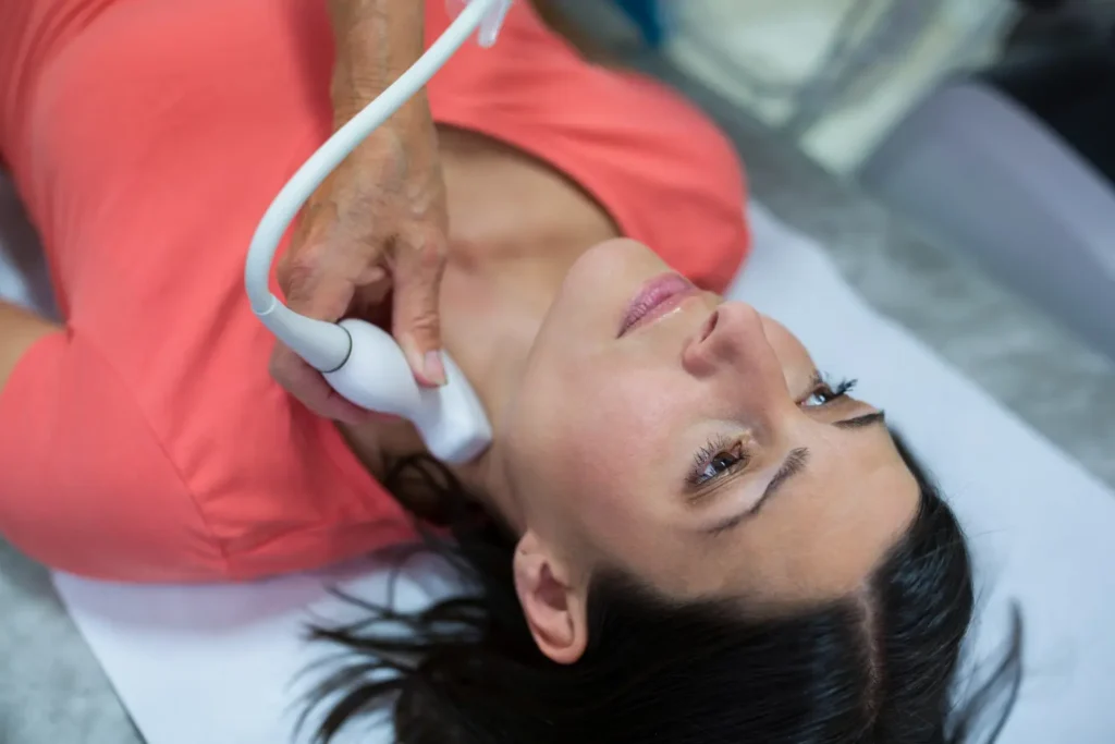 Imagem de uma mulher realizando uma consulta com um transdutor de ultrassom portátil.
